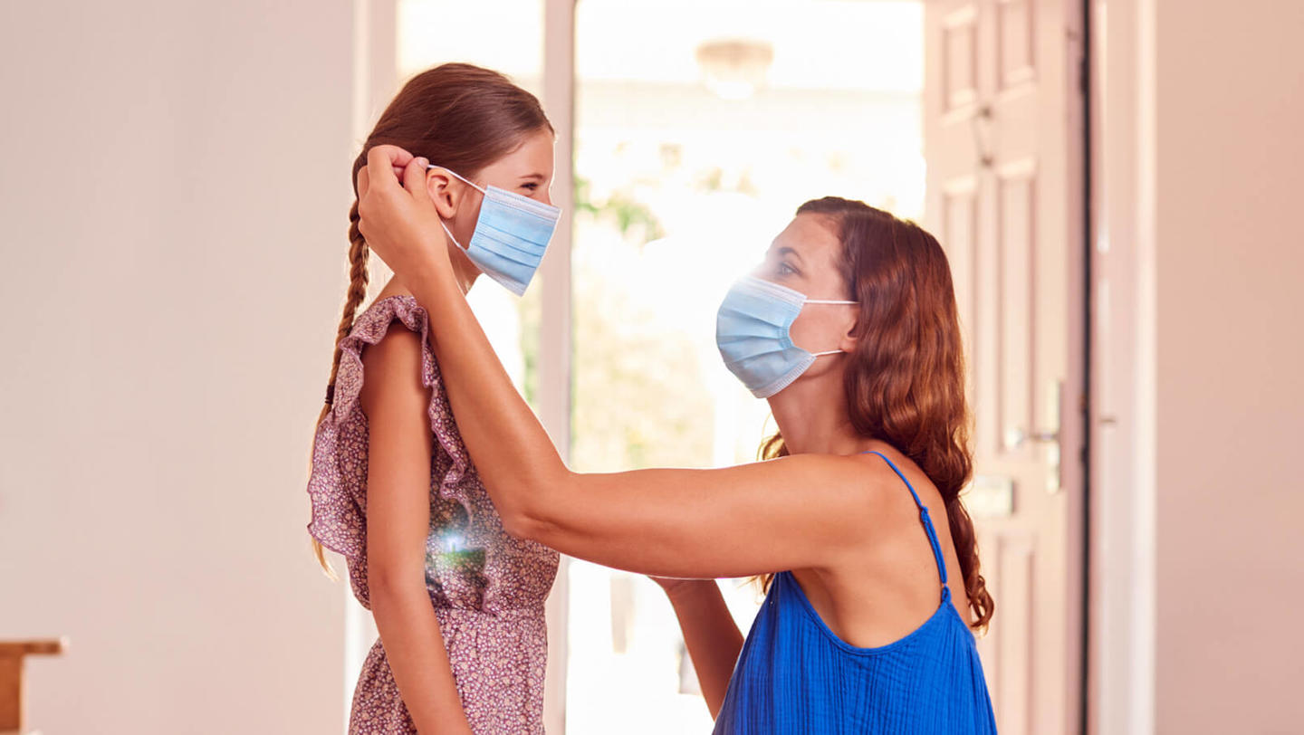 a woman puts a mask on her child