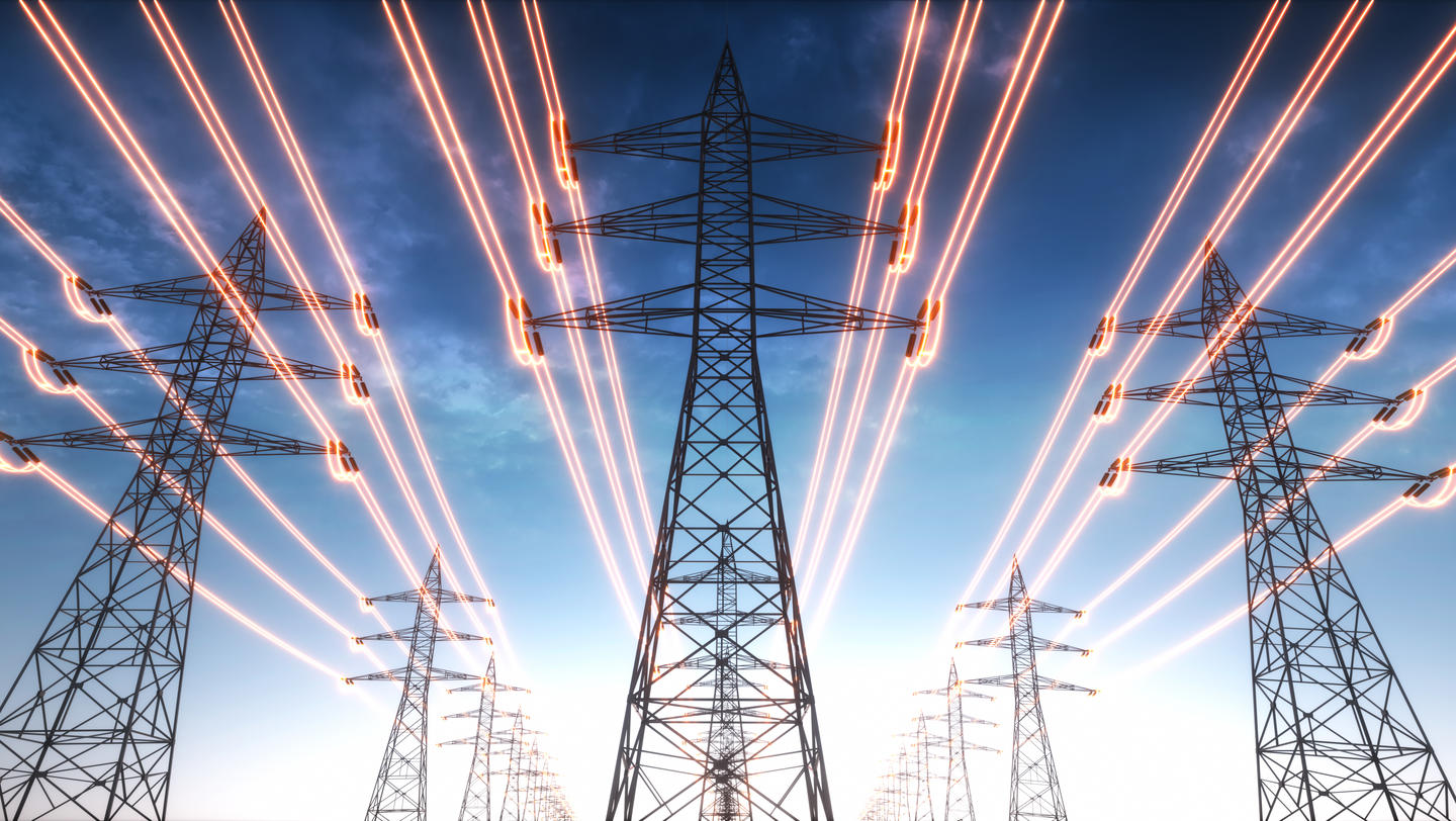 Electricity transmission towers with red glowing wires