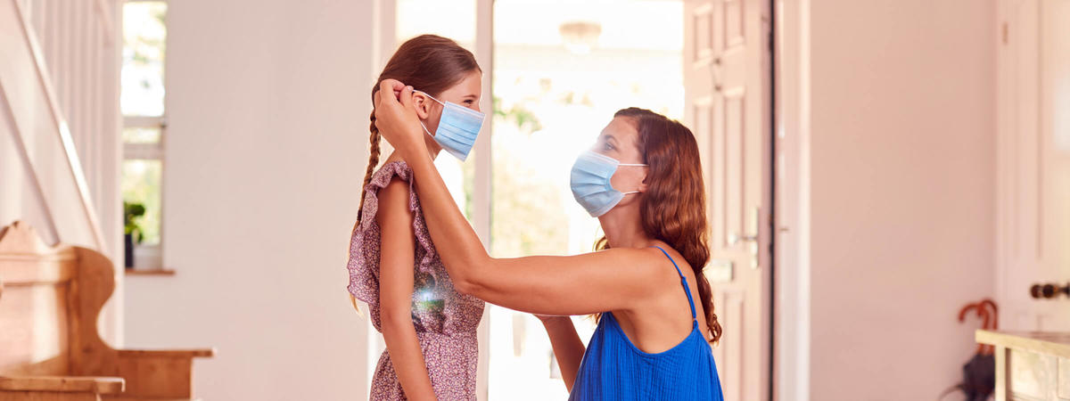 a woman puts a mask on her child